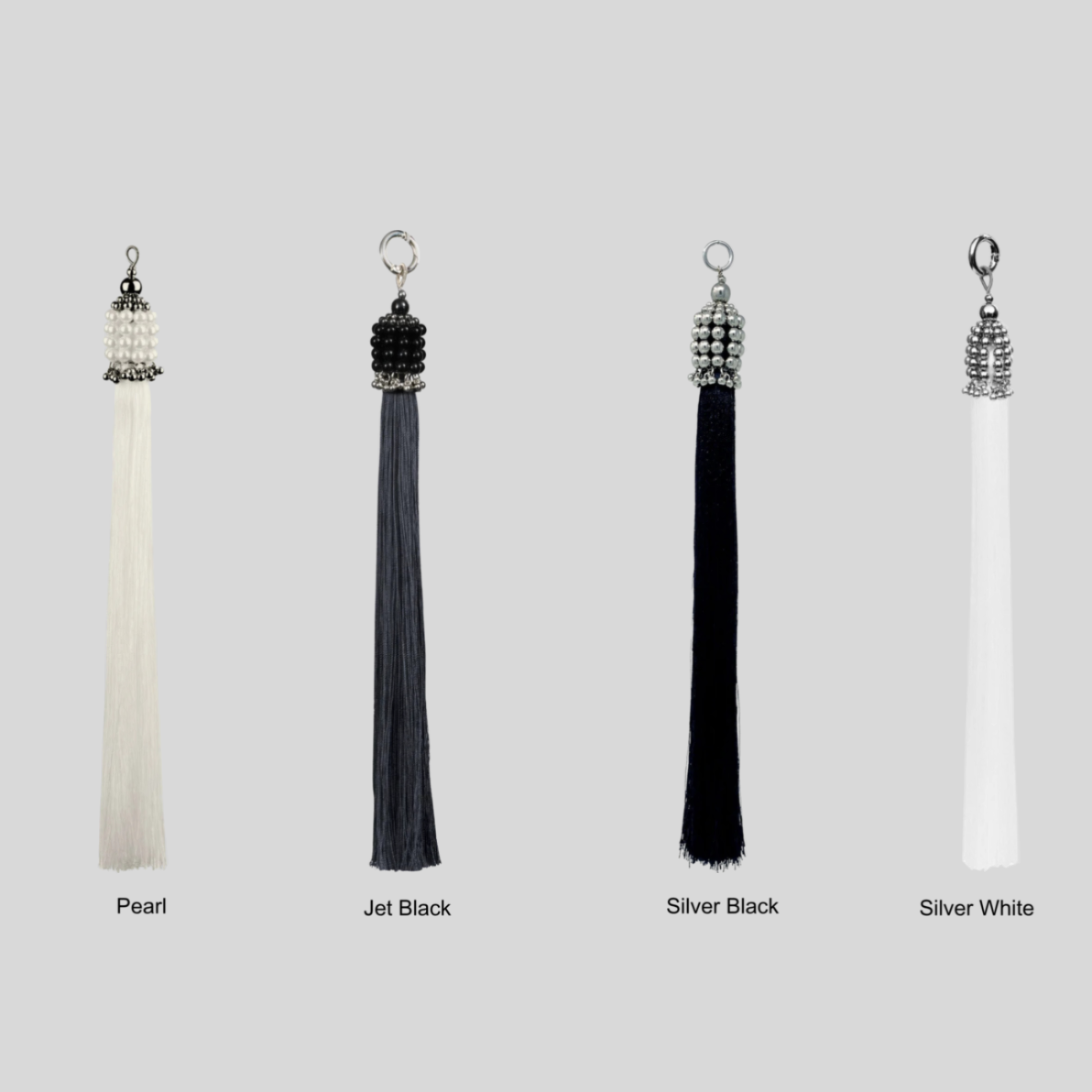Set of four tassels in different colors with siver, pearl, and black crsytal beads on a grey background by Object&Dawn