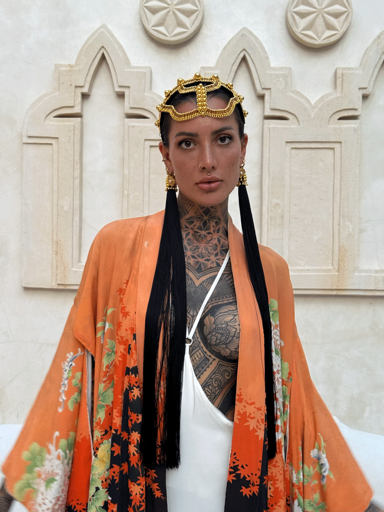 woman standing in unique bacground wearing Tamoe Silk Harness Skirt in White with Antique Kimono and Khutulun Headband gold with 22" long Tassel Gold-Black  by Object&Dawn