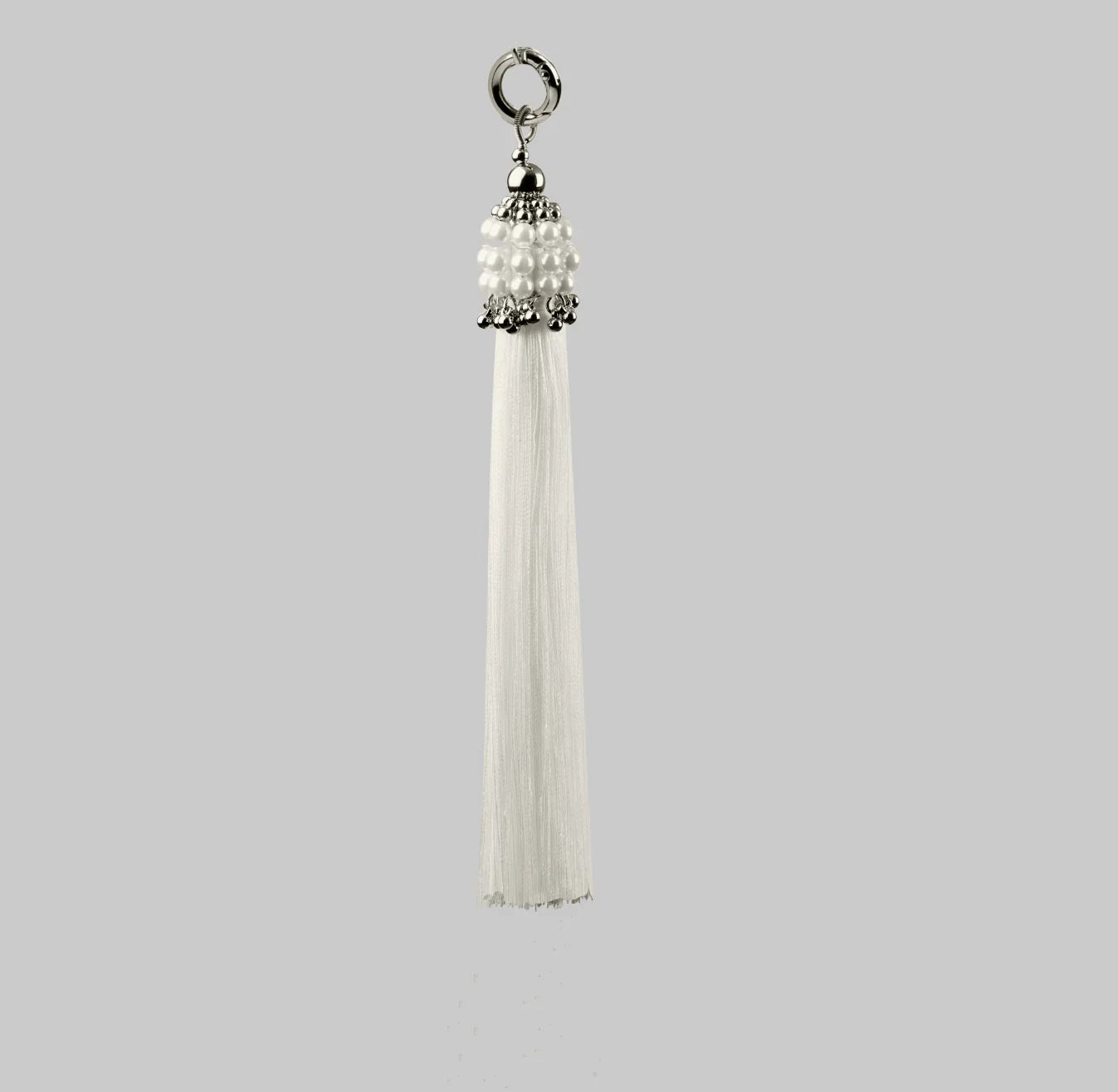 Beaded handcrafted polyester tassel by silver coated metal beads with systethic japanese pearl on grey background