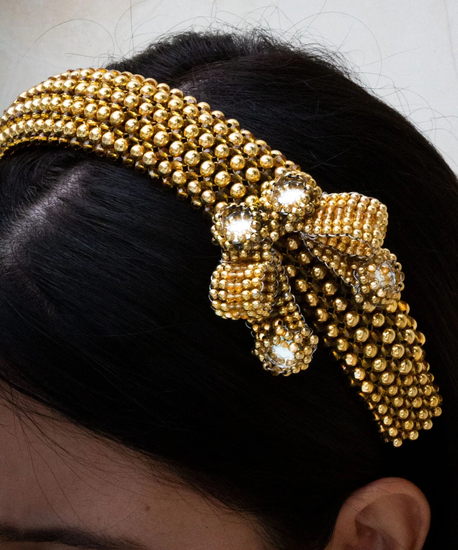 Gold beaded Amaya Bow headband worn by a person with a neutral background