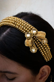 Gold beaded Amaya Bow headband worn by a person with a neutral background
