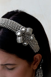 Object & Dawn Amaya Bow Headband silver detail view worn by woman in neutral bankground
