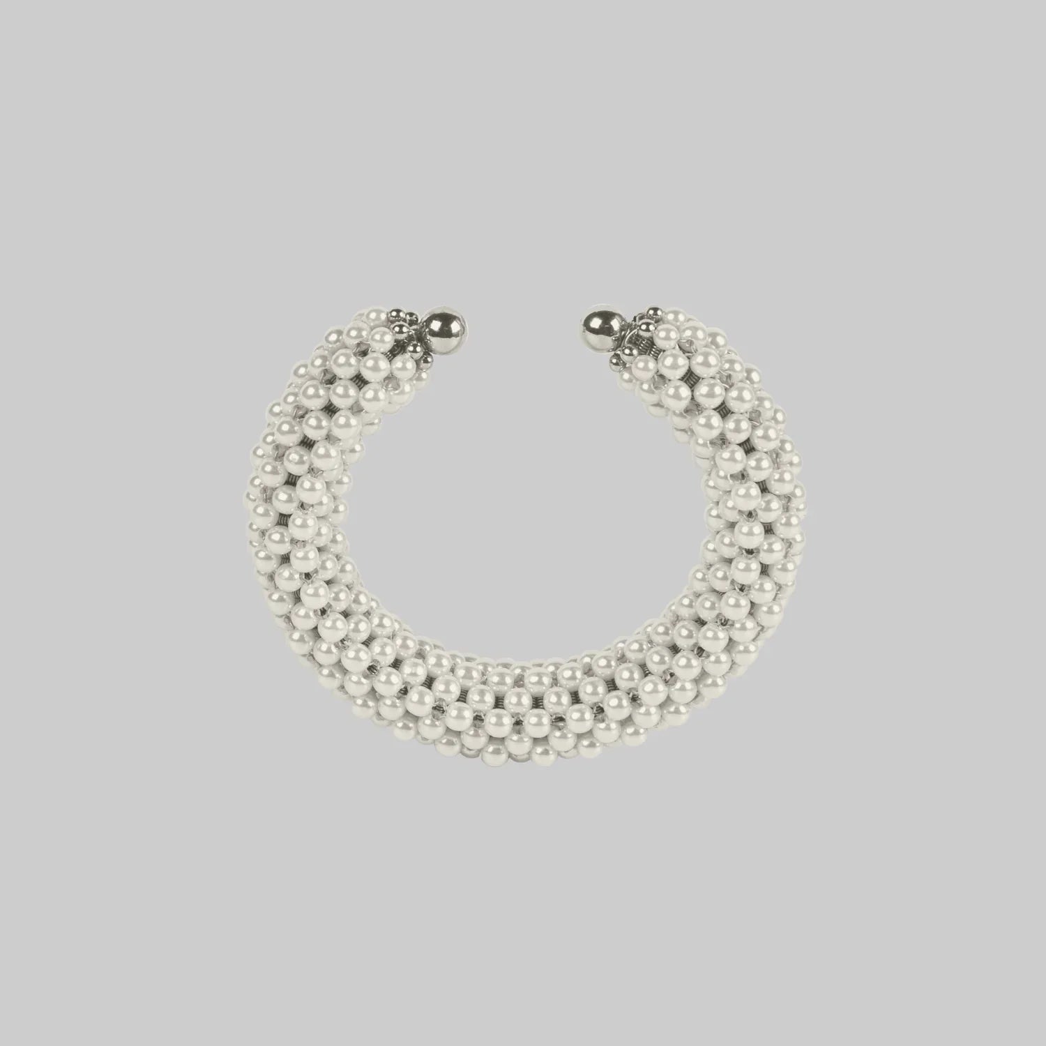 Handcrafted modular bracelet cuff from syntethic japanese pearl on neutral background up view
