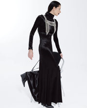 Woman wearing a black evening gown with a silver embellished top on a white background