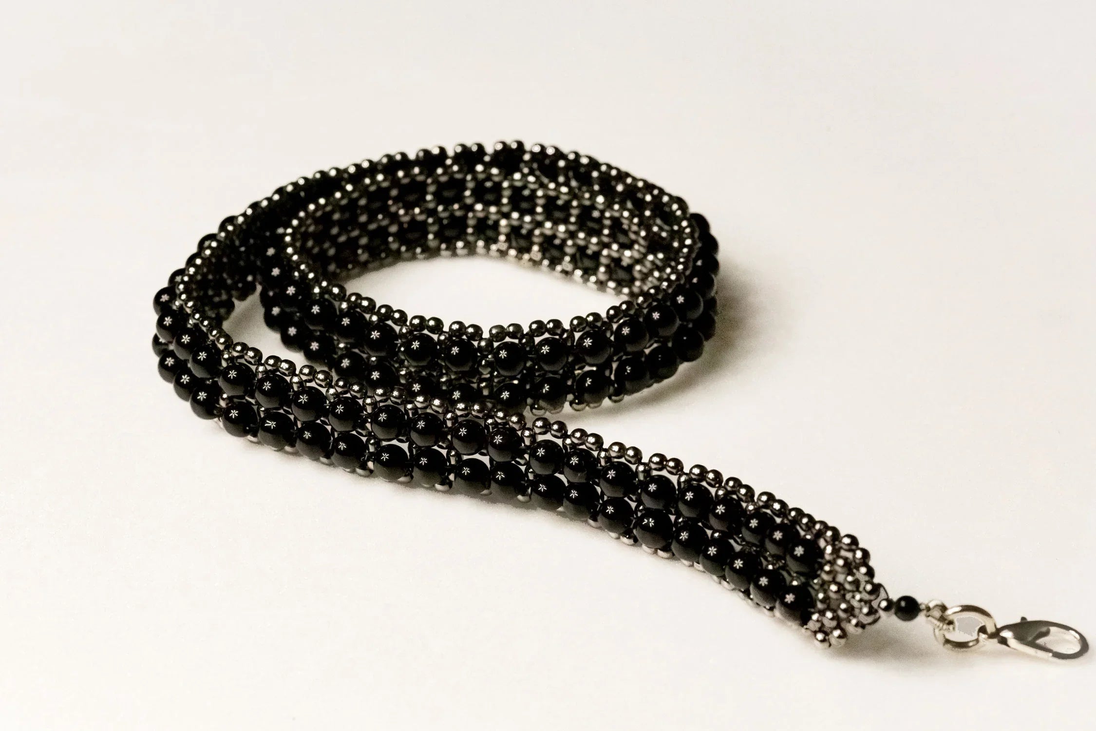 beaded modular hat band for hat accecories by object and dawn in white background close up logo view