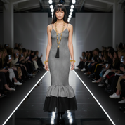 Woman walking on a fashion show runway wearing a gray dress with Beaded Link Necklace by Object & Dawn