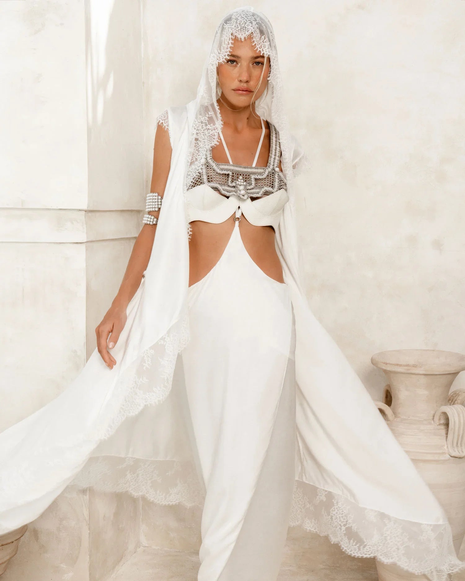 woman wear bride oufit in white robe lace with handcrafted modular beads crown and harness in pearl by object and dawn