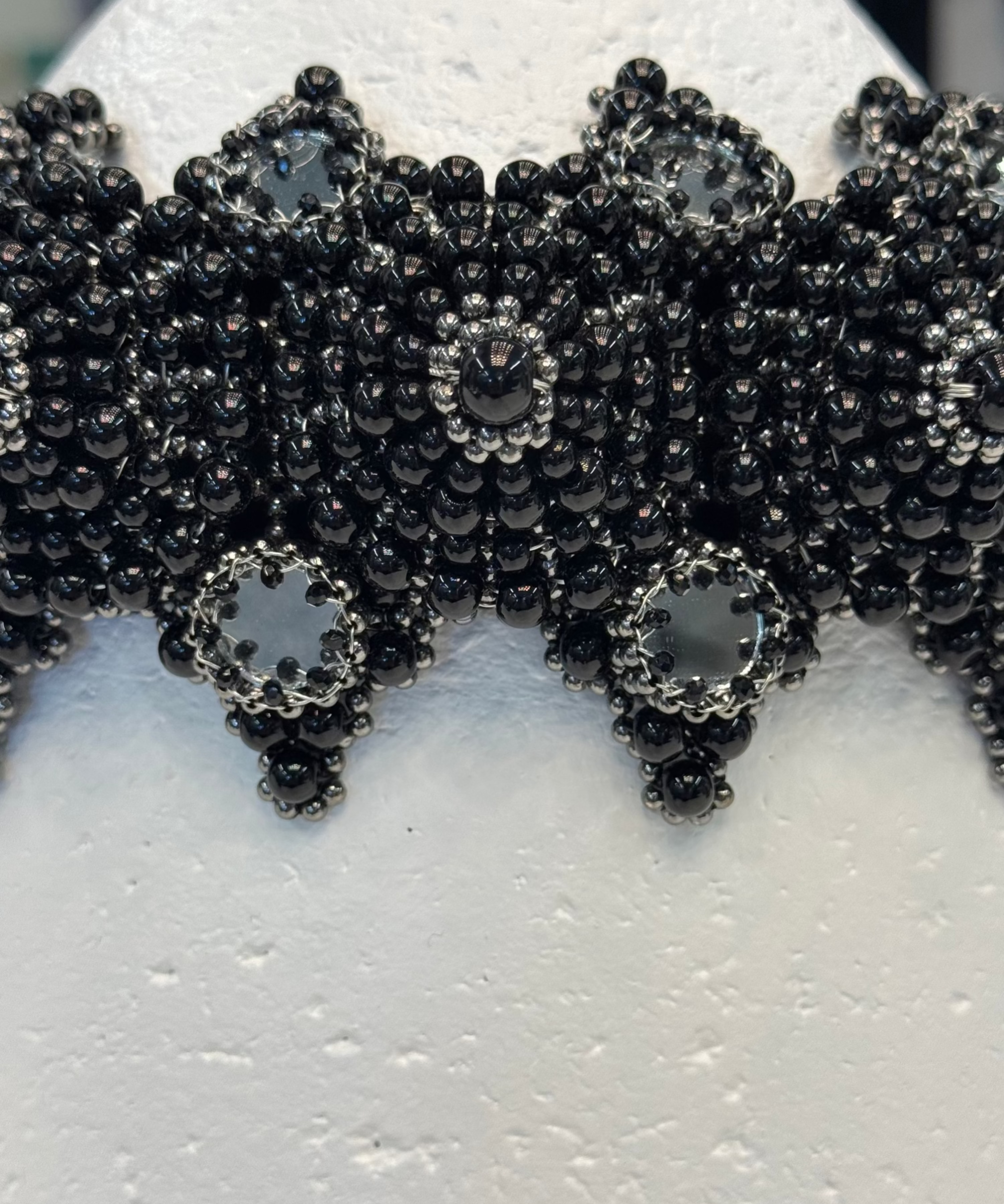 handcrafted modular crown with silver coated polymer beads and black crystal by object and dawn ghost image in white background close up view