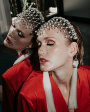 Woman wearing a red outfit with decorative freja headband against a mirror background