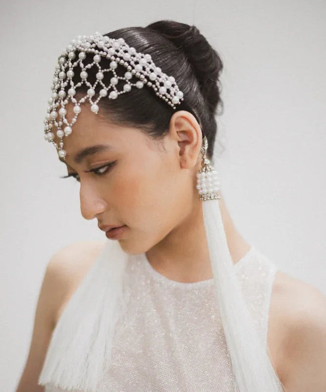 East asian bride wearing Freja Headband in Pearl with two white 11" tassels. 