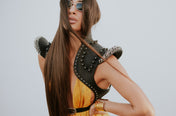 woman in orange dress wears helios leather bolero in white background