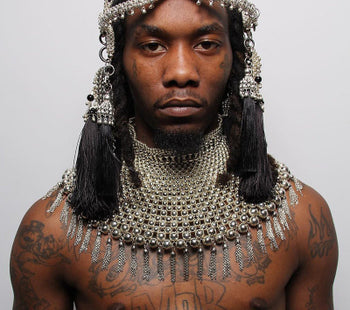 Offset wearing elaborate silver headpiece and necklace by Object &amp; dawn on a plain background