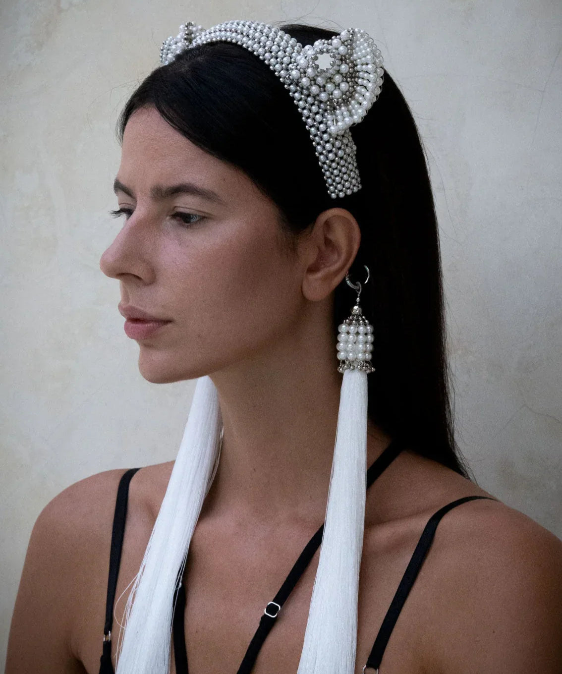 Woman in black outfit wears Jas Headband pearl with 11" tassels pearl by Object & Dawn in neutral backgorund
