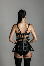 woman with premium leather studded cage top black on grey background back view