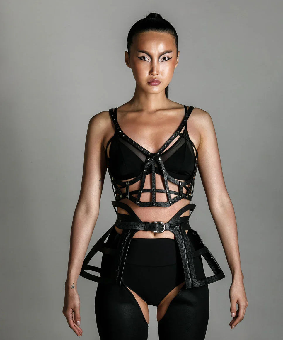 woman with premium leather studded cage top black on grey background