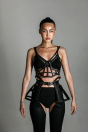 woman with premium leather studded cage top black on grey background