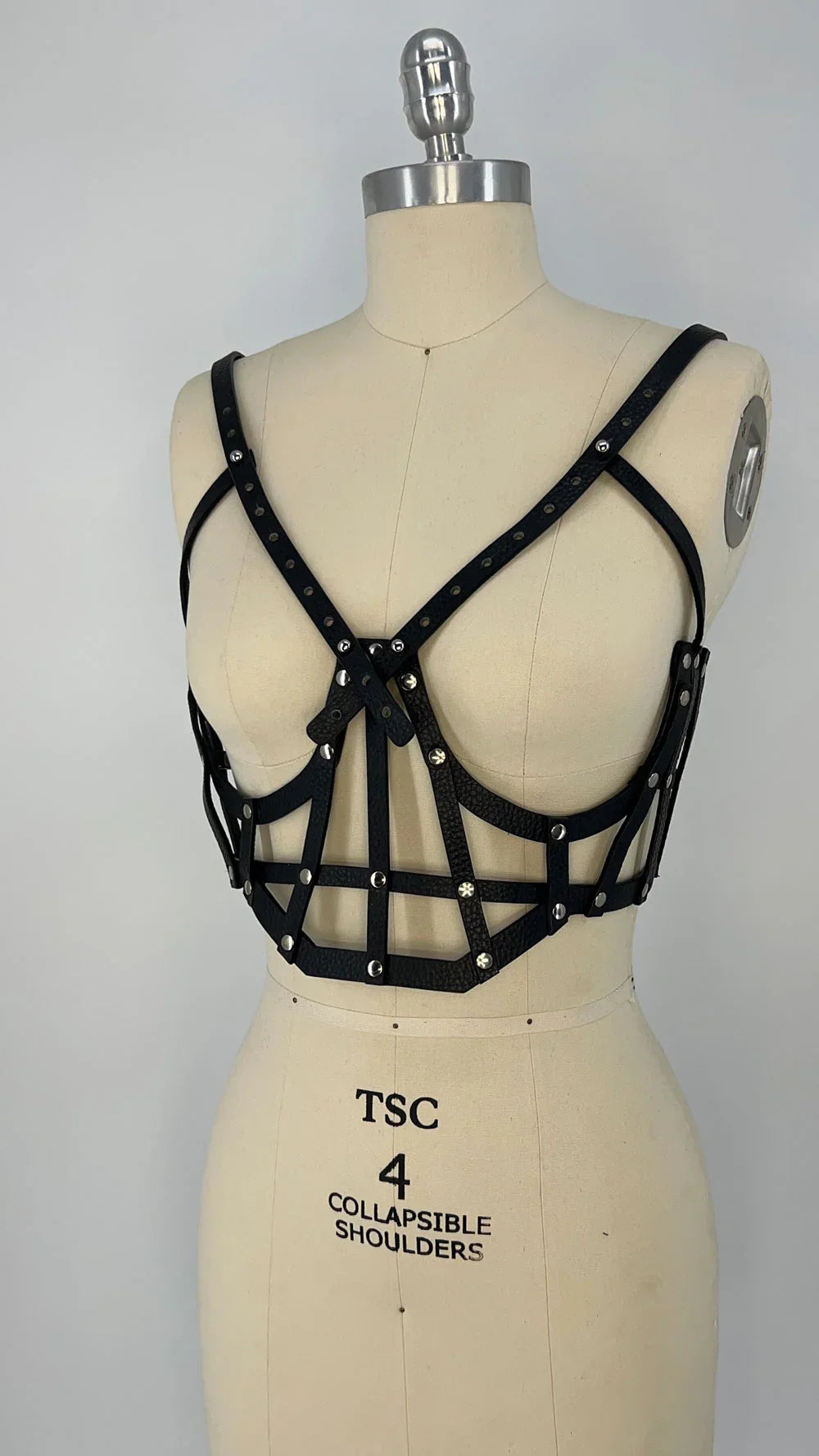 ghost image premium leather studded cage top black on mannequinwith  grey background front view