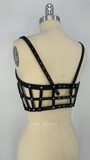 ghost image premium leather studded cage top black on mannequinwith  grey background back diagonal