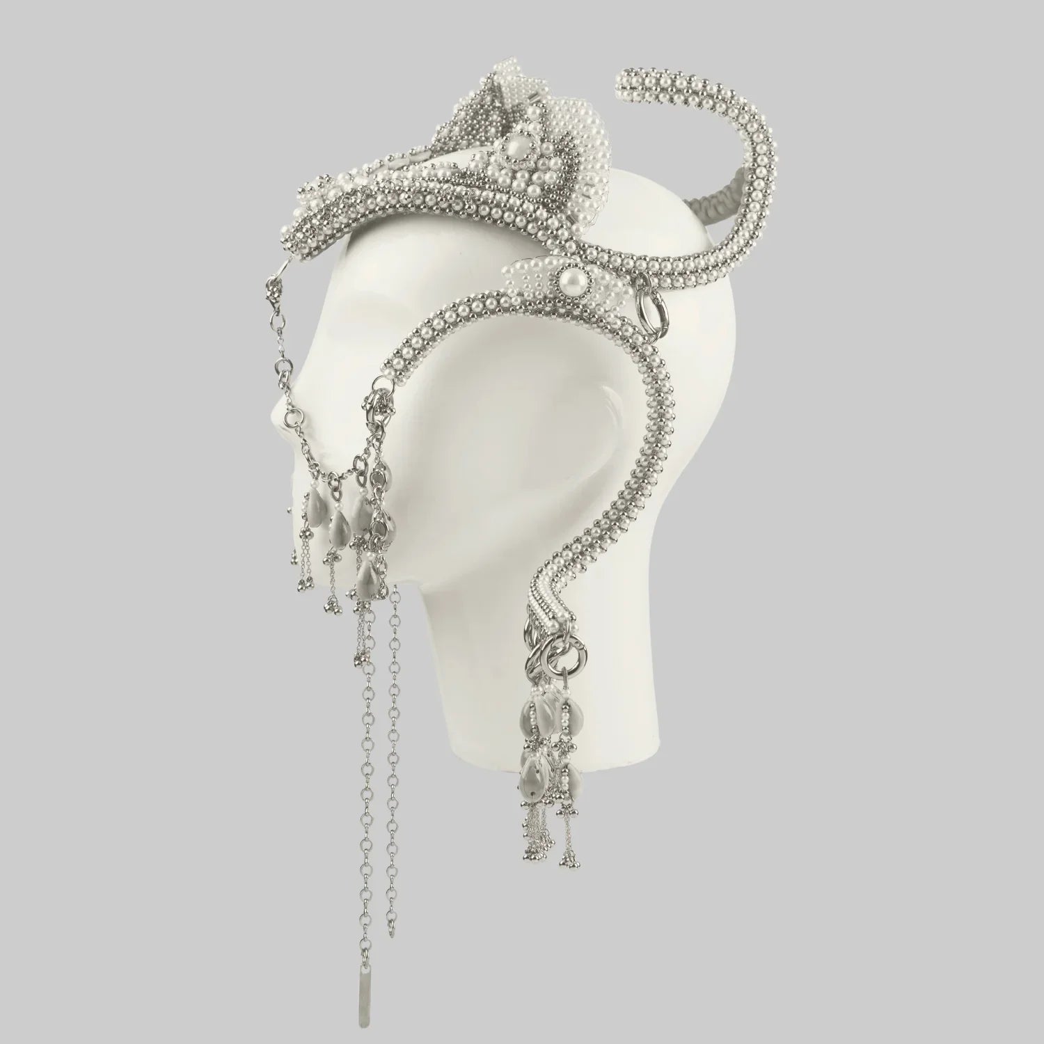 Object and Dawn, modular headpiece system in pearl with removable tassels and pearl medallion in grey background, ghost image side view