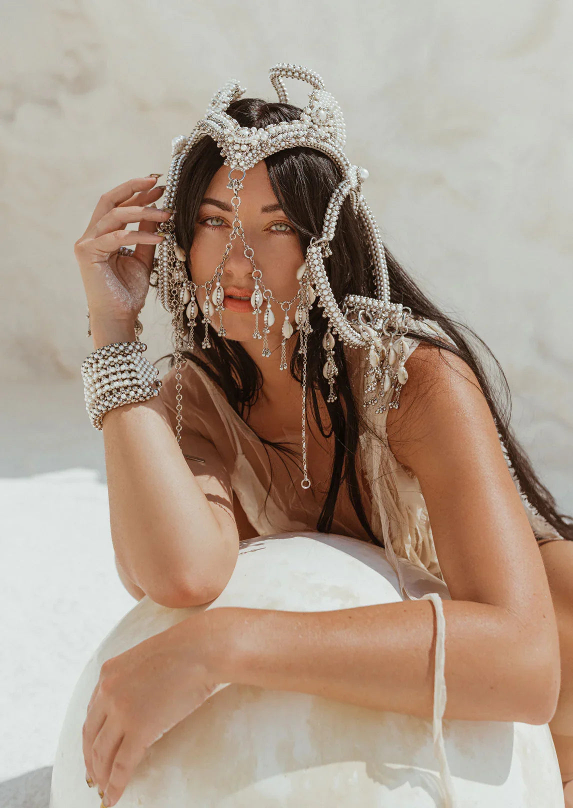 woman in white background with modular headpiece system in pearl with removable mask and pearl cowrie tassels in grey background, ghost image front by Object&Dawn