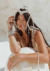 woman in white background with modular headpiece system in pearl with removable mask and pearl cowrie tassels in grey background, ghost image front by Object&Dawn