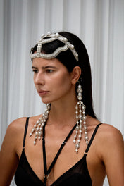 Woman wearing a decorative Khutulun Pearl headband with trinity medallions by Object & Dawn on a grey background