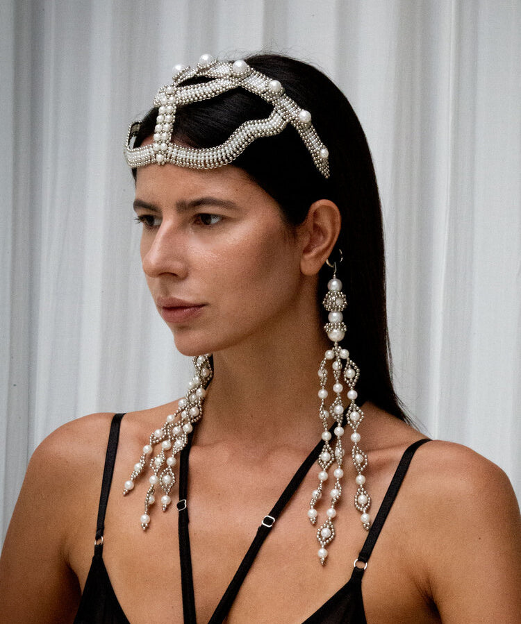 Woman wearing a decorative Khutulun Pearl headband with trinity medallions by Object & Dawn on a grey background