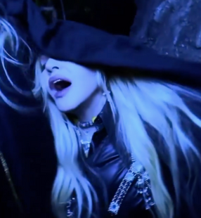 Madonna wearing Object &amp; Dawn harness in video. Blue toned lighting.