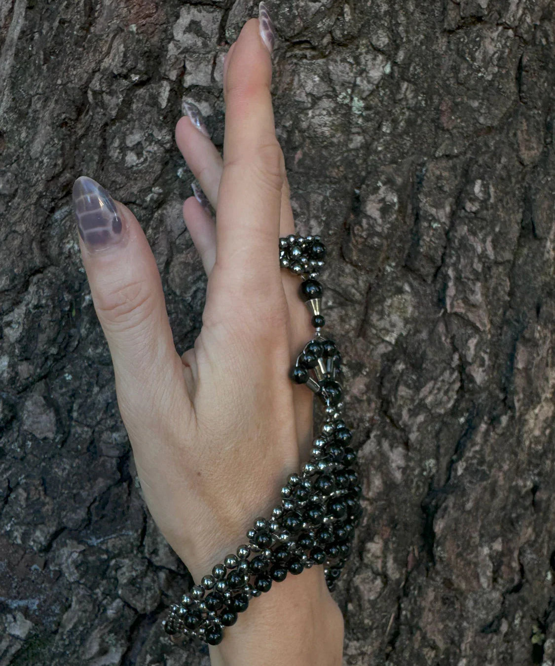 luxury beaded hand jewelry polymer metal beads and crystal black on hand with wood background by object and dawn