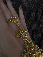 beaded detail of modular hand jewelry and ring in gold by object and dawn close up