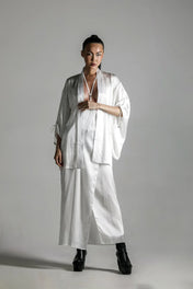 short white silk kimono with white harness skirt worn on woman by object and dawn at neutral background front view