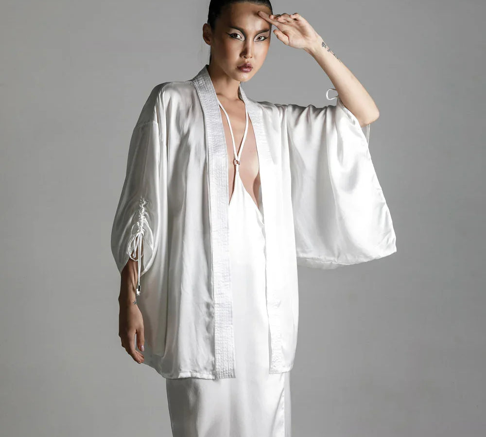 short white silk kimono with white harness skirt worn view up by object and dawn at neutral background