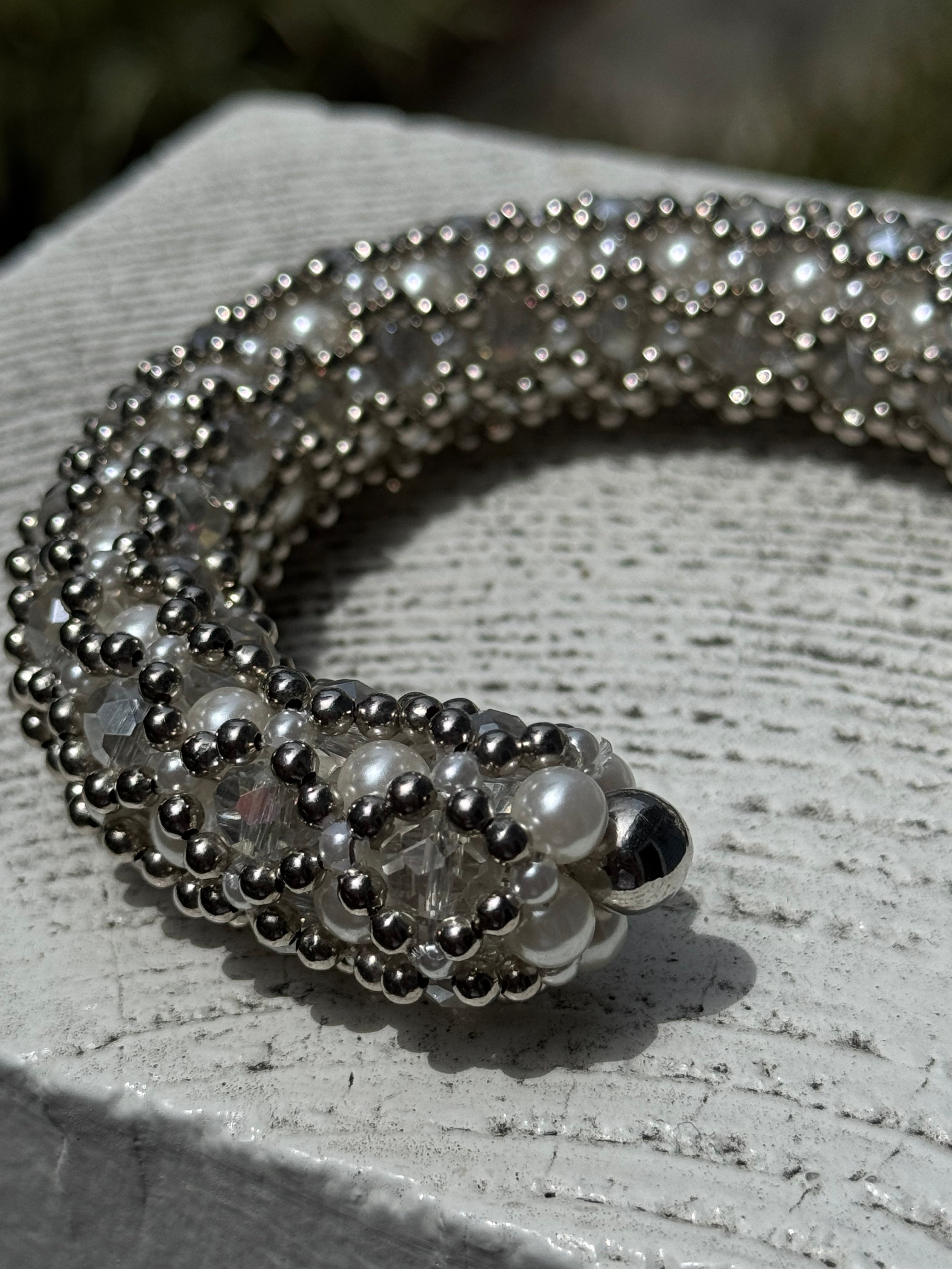side close-up of handcrafted beaded cuffs with crystal and pearl embellishments in silver tone by object&dawn
