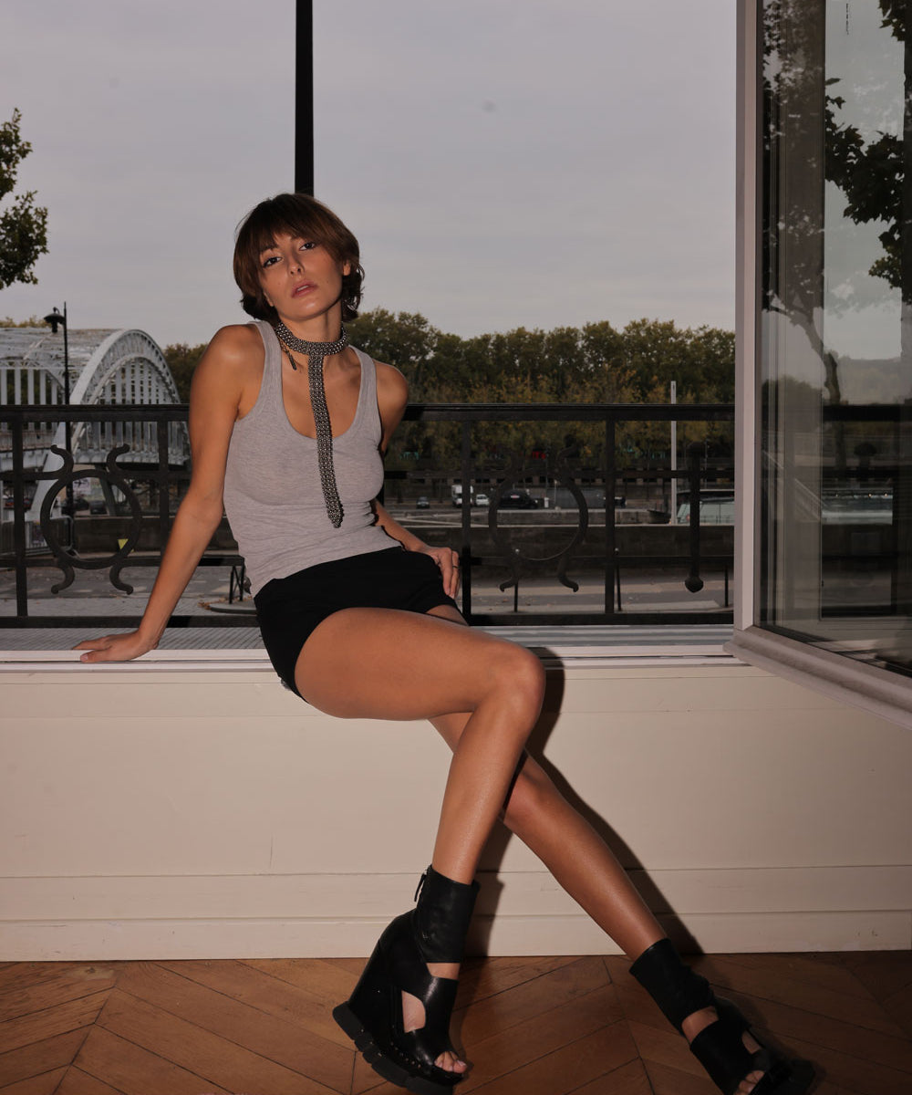 Woman wearing a gray tank top with a decorative signature t-shaped beaded necklace in an outdoor setting by Object&Dawn.
