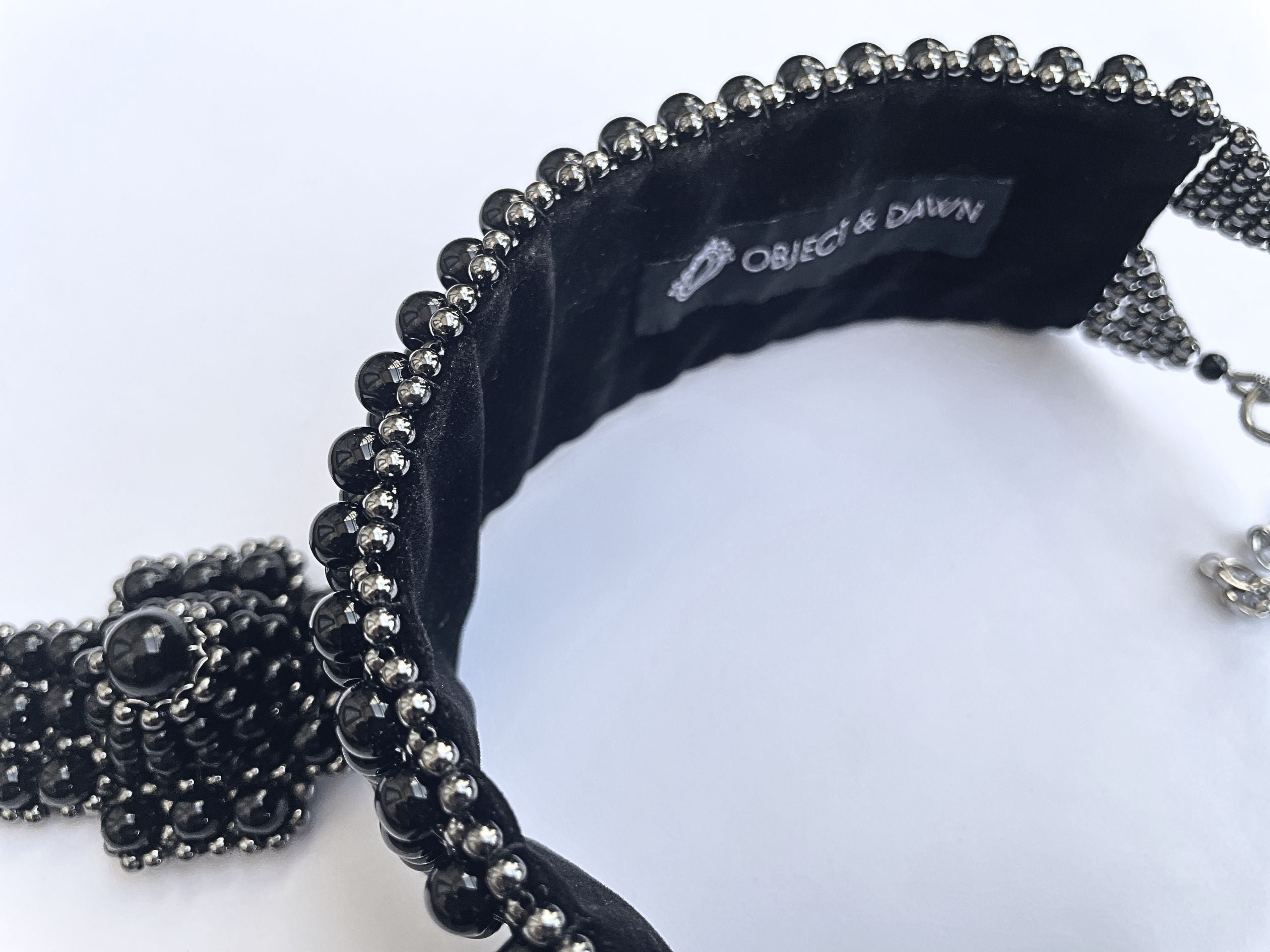 Black beaded headband with 'Object & Dawn' branding on a white background