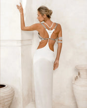 khutulun top with white harness skirt worn on woman by object and dawn at neutral background back view