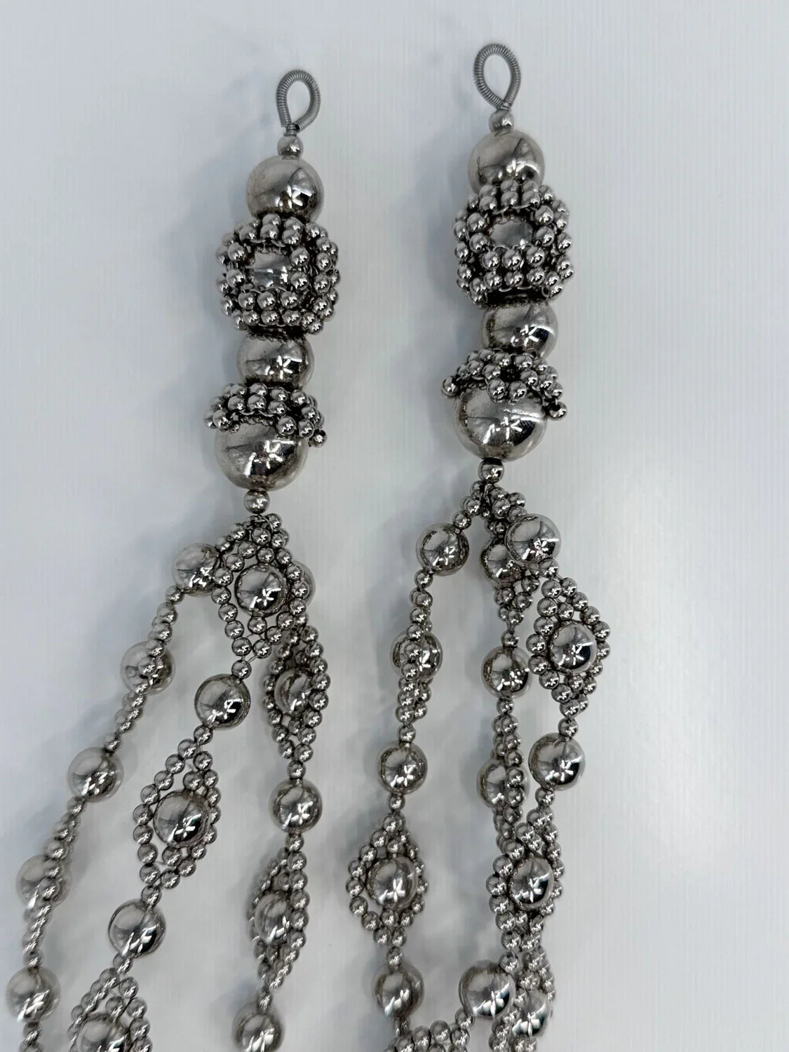 Beaded medallions from polymer metal beads by object and dawn on neutral background