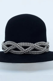 Beaded modular accessory on black hat from polymer metal beads by object and dawn on neutral background