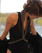 Woman in a black dress with V-Neck Beaded Harness, leaning against a railing with the Eiffel Tower in the background.
