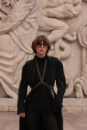 Woman wearing a black outfit with V-Neck Beaded Harness in front of a stone sculpture by Object & Dawn