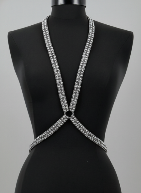 Silver strappy top on a black mannequin against a gray background