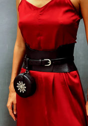 close up woman in red dress wearing zheng corset belt with leather coin bag by object & dawn in neutral background