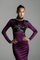 Woman wearing a purple dress with Zeitan Leather Beaded Bra Top by Object & Dawn against a gray background