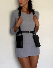Woman wearing a gray dress with black harness against a white background