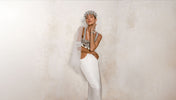 Woman wearing a Tamoe Harness Skirt White with Eingana Crowm, Khutulun Modular Top with Leather Bra and Mata Hari Jewelry in Pearl by Object & Dawn against a plain background