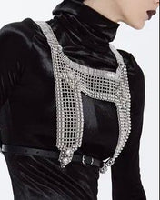 Black velvet outfit with a decorative silver harness on a white background