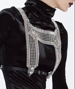 Black velvet outfit with a decorative silver harness on a white background