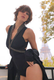 brown haired woman in a black one piece wearing a v-neck beaded necklace harness from Object & Dawn, standing outdoors.