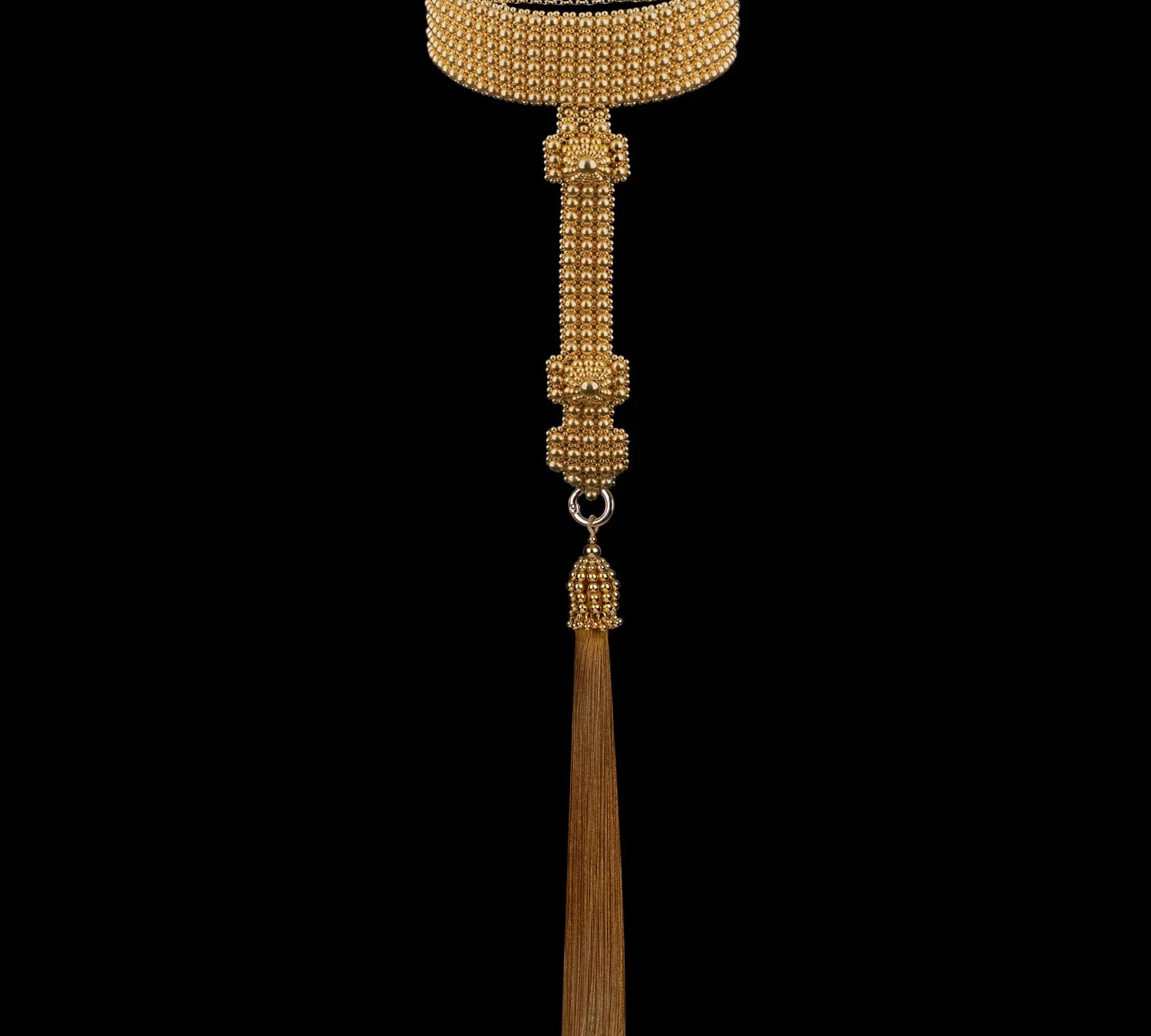 Gold beaded T-shaped choker with a tassel on a black background by Object & Dawn